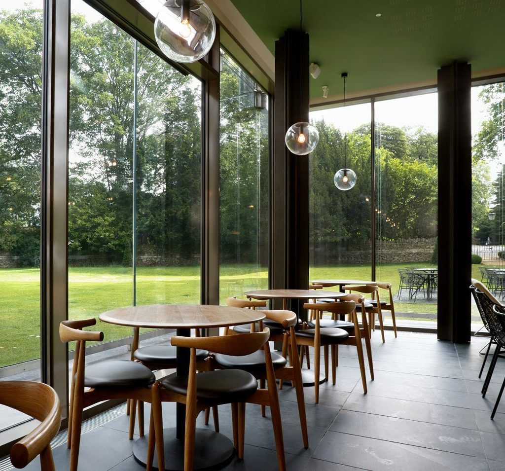 Chairs and tables by the glass walls of the Garden Cafe